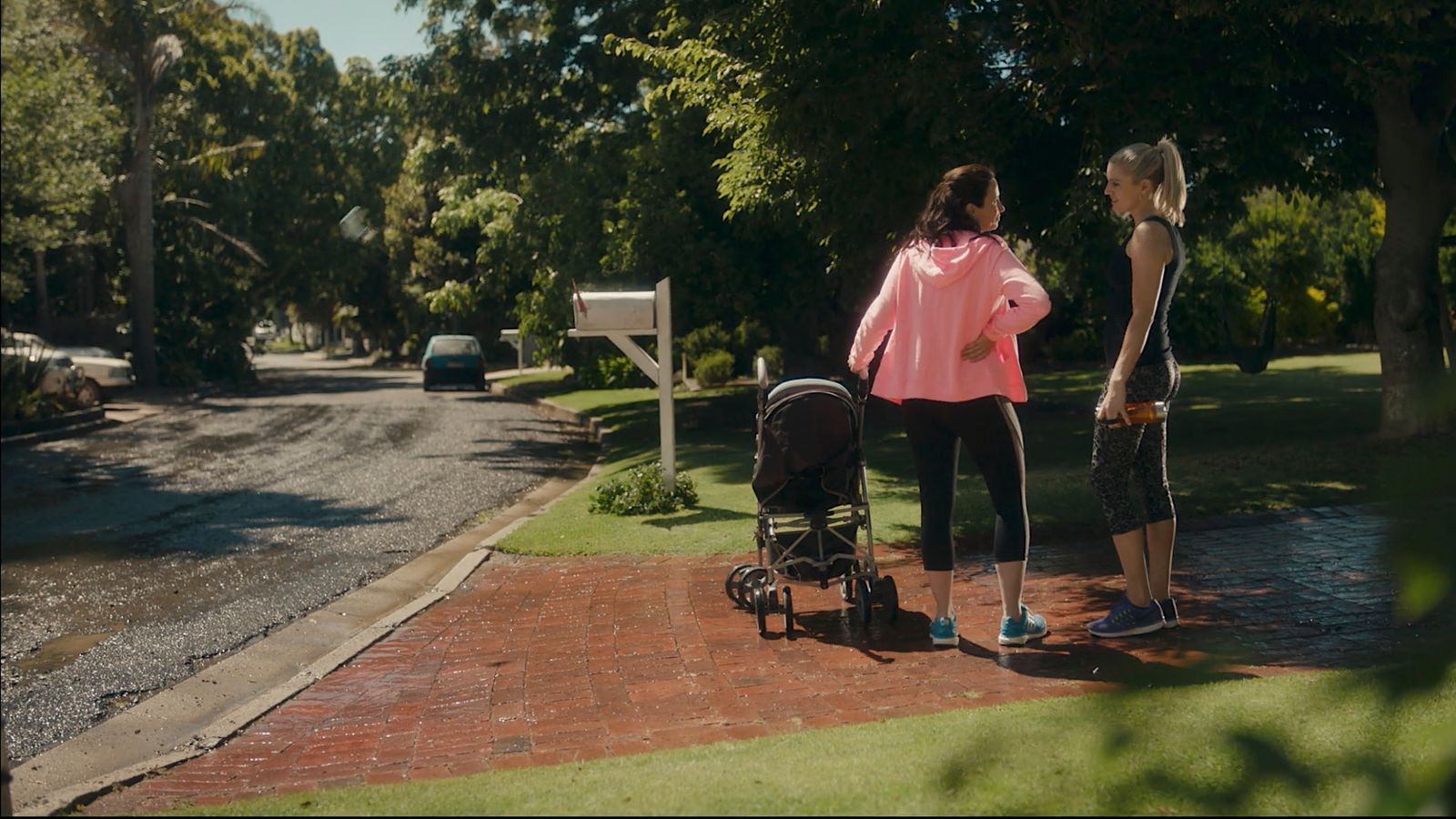 a couple of women standing next to a baby carriage