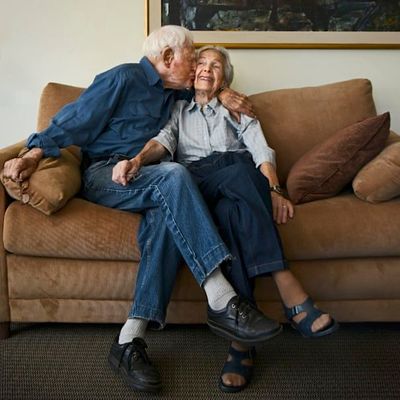 an older man and woman sitting on a couch