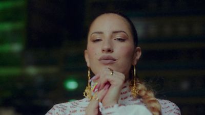 a woman in a red and white shirt and gold earrings