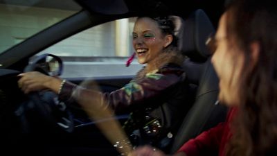 a woman driving a car with a creepy look on her face