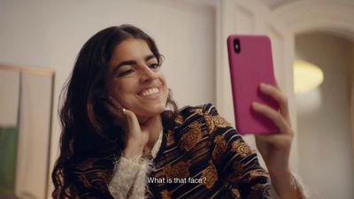 a woman holding a pink cell phone up to her face