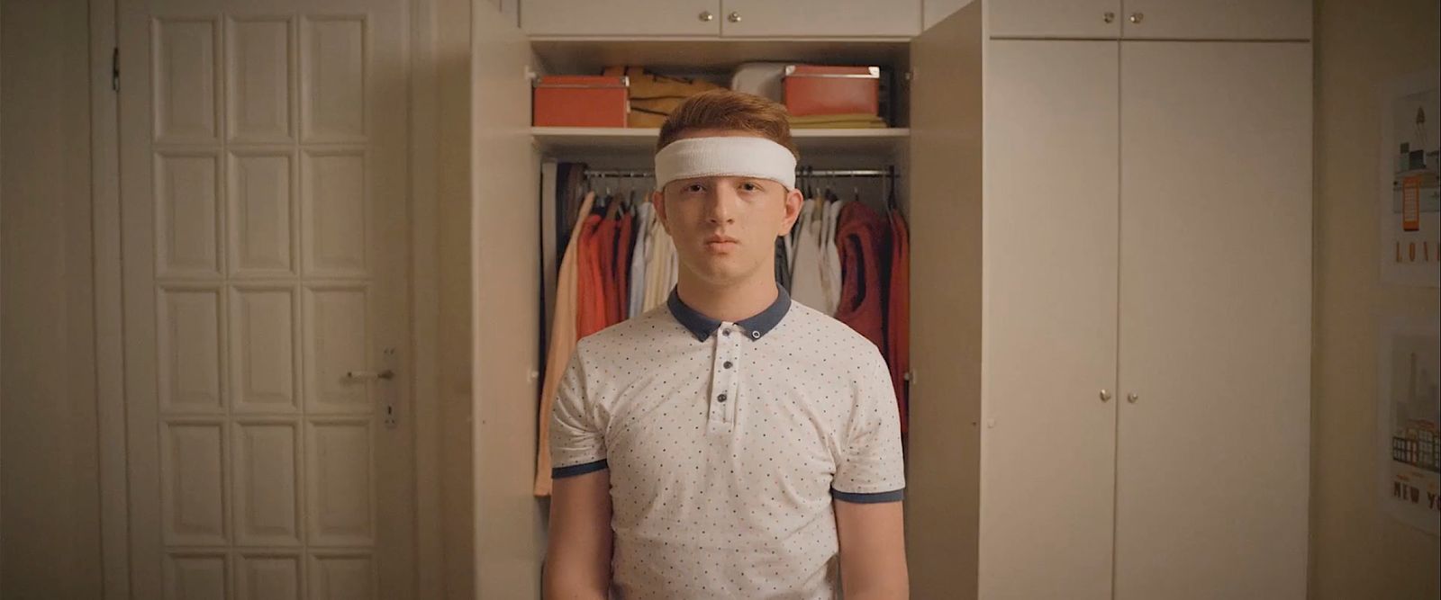 a man with a blindfold standing in a closet