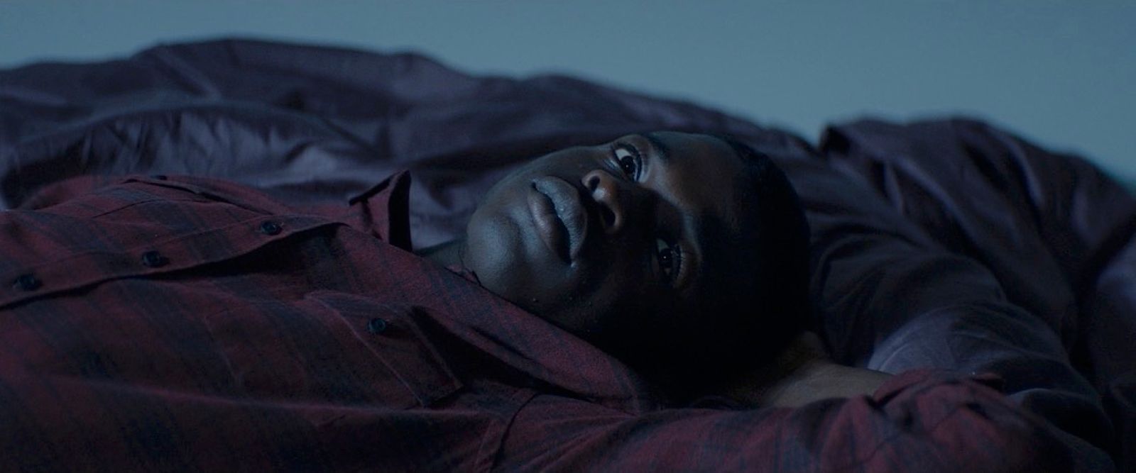 a man laying on a bed with his eyes closed