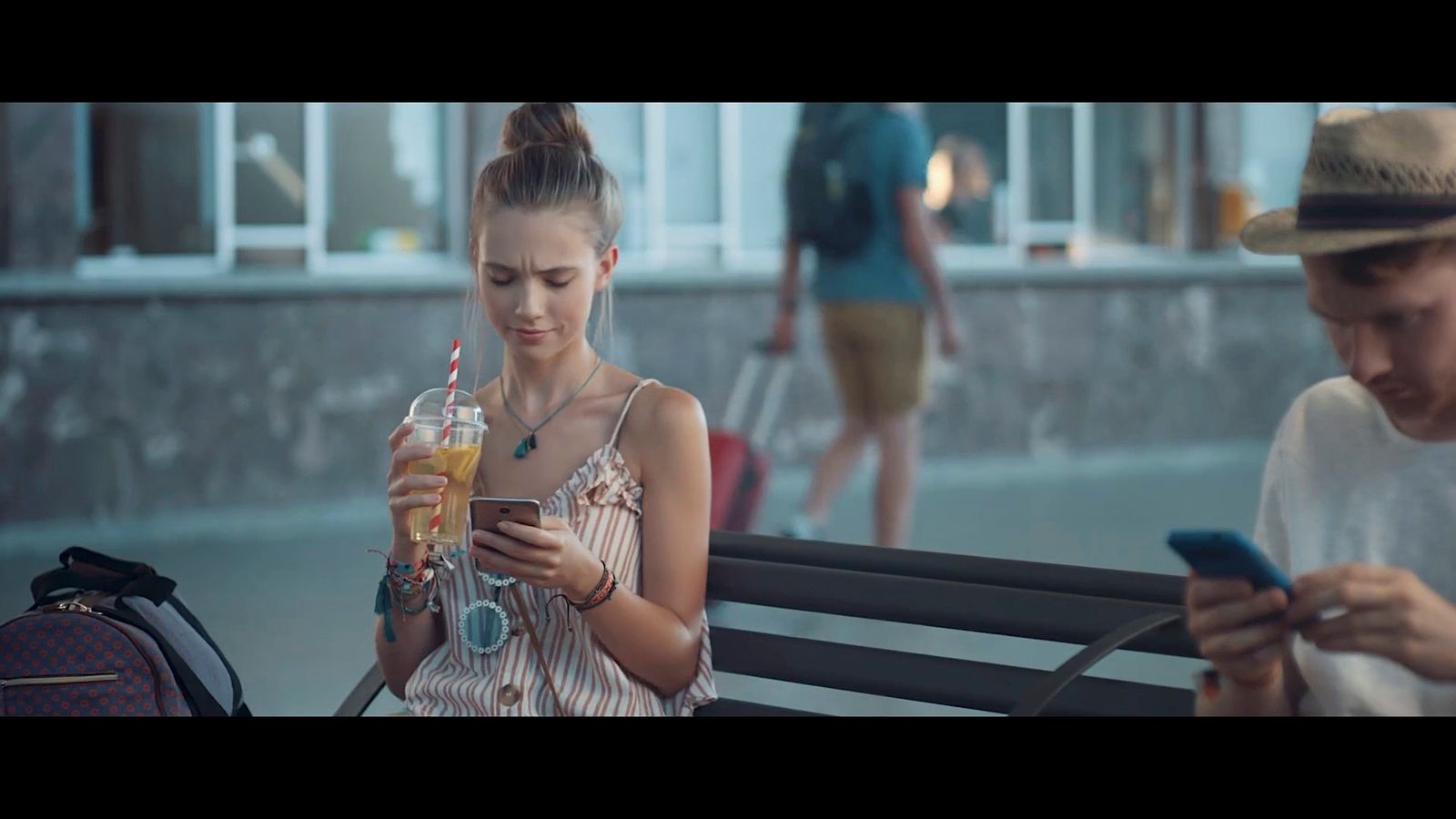 a woman sitting on a bench while looking at her cell phone