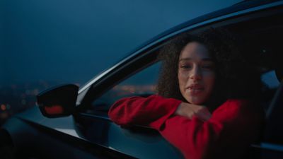 a woman sitting in a car looking out the window