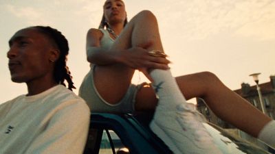 a man and a woman sitting on top of a car