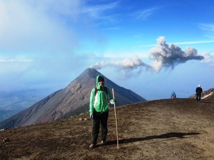 a man standing on top of a mountain holding a stick