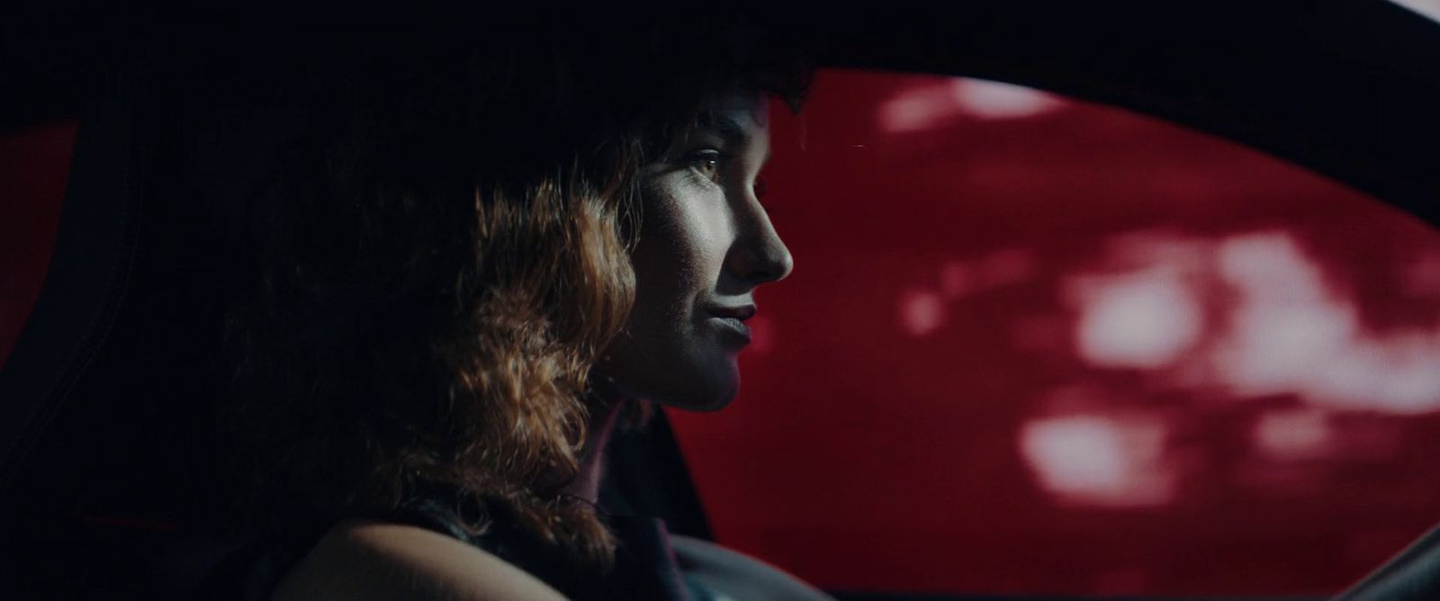 a woman sitting in a car looking out the window