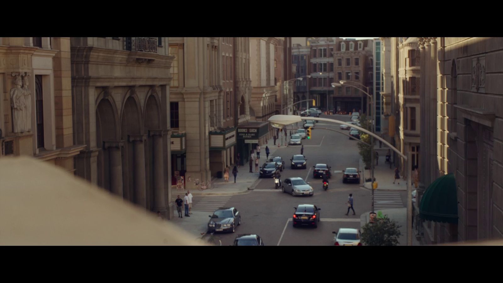 a city street filled with lots of traffic next to tall buildings