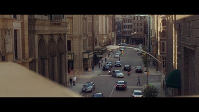 a city street filled with lots of traffic next to tall buildings