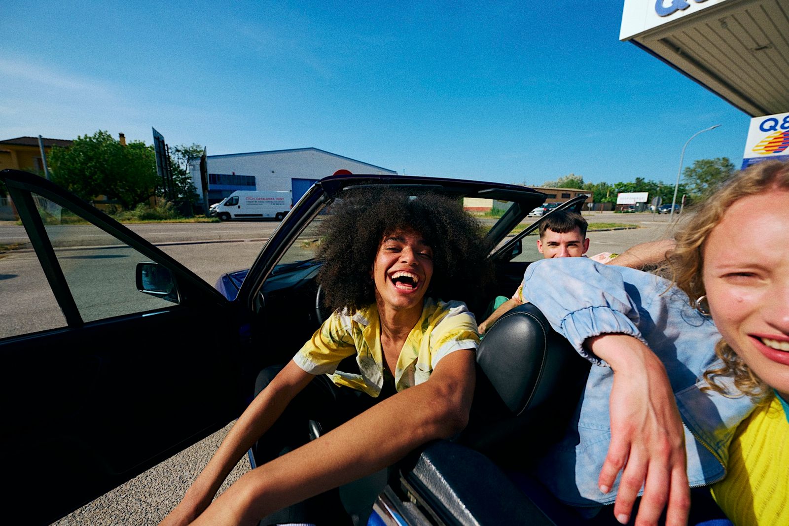 a woman sitting in the back of a car next to a man