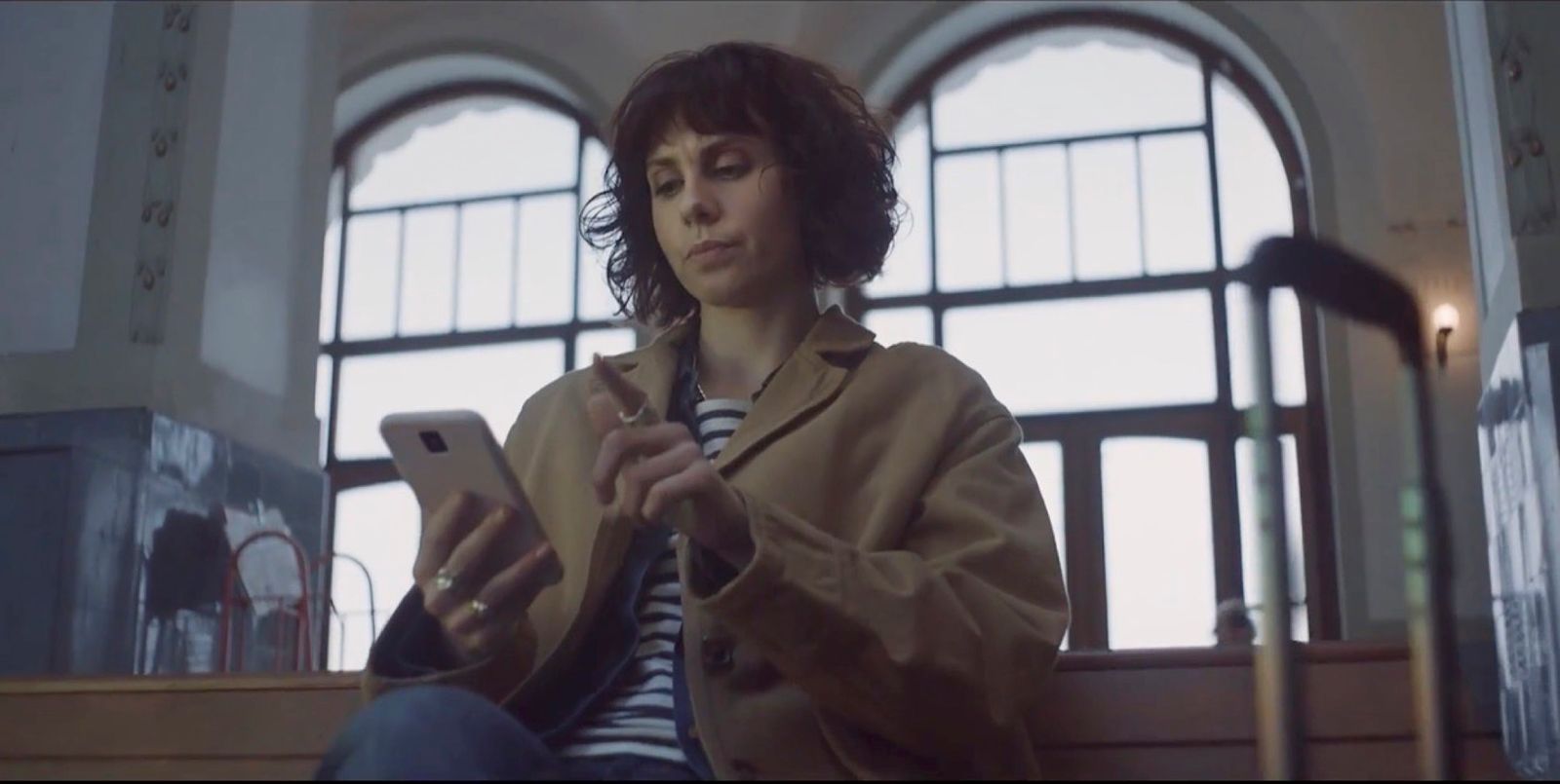 a woman sitting on a bench using a cell phone