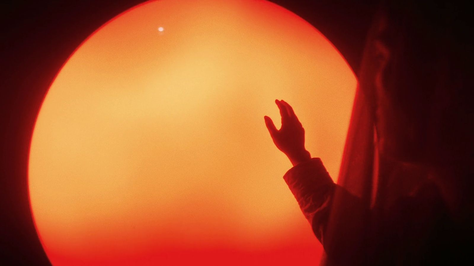 a person standing in front of a large sun