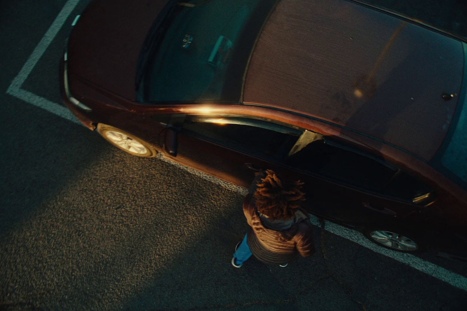 a person standing next to a brown car