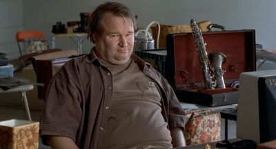 a man sitting in front of a desk with a keyboard