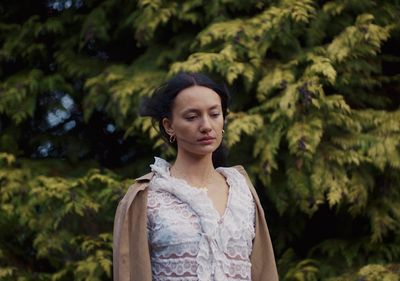 a woman standing in front of some trees