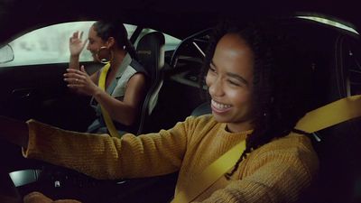 a woman sitting in a car with a steering wheel