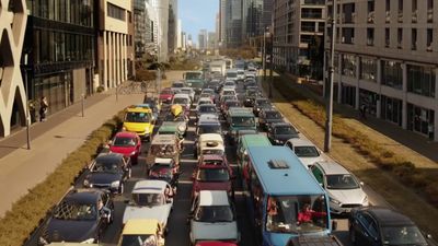 a city street filled with lots of traffic next to tall buildings