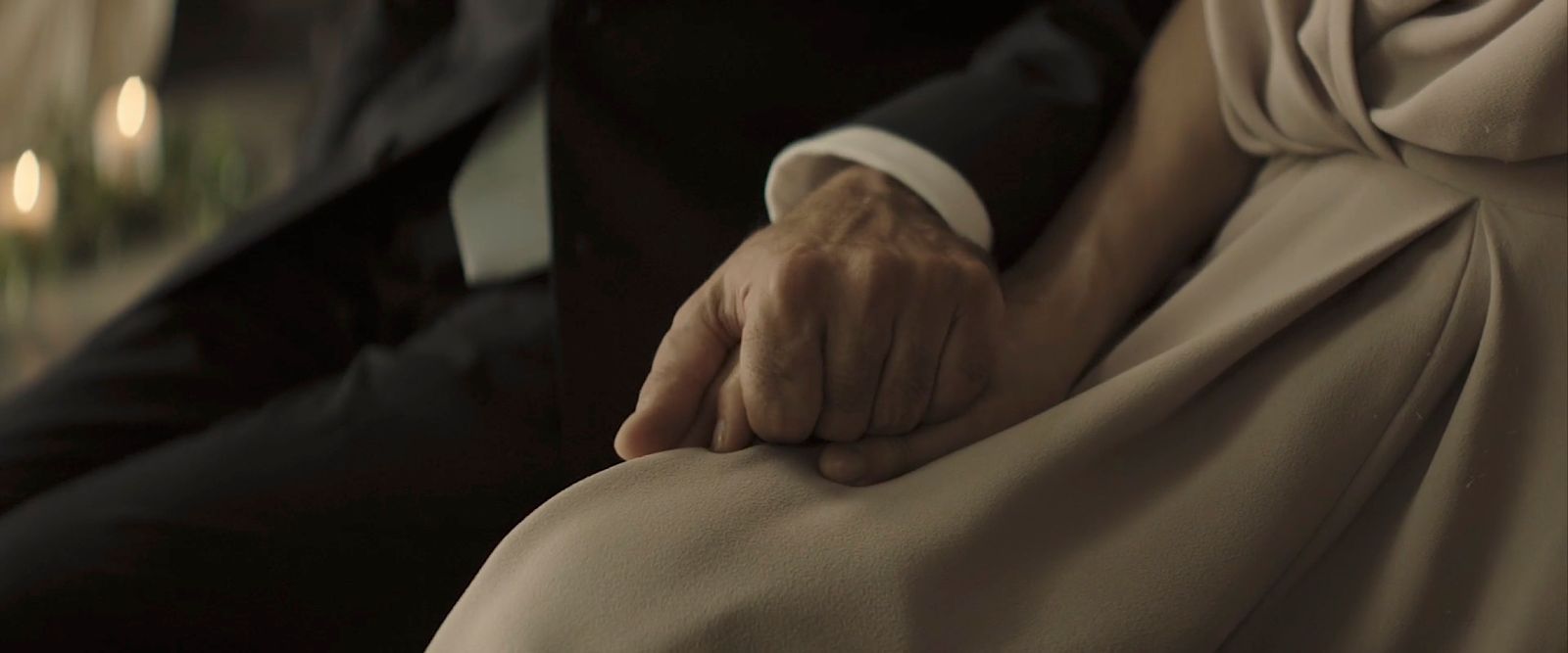 a close up of a person in a tuxedo holding another person's