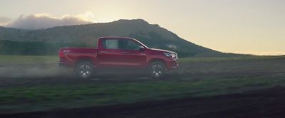 a red truck driving down a dirt road