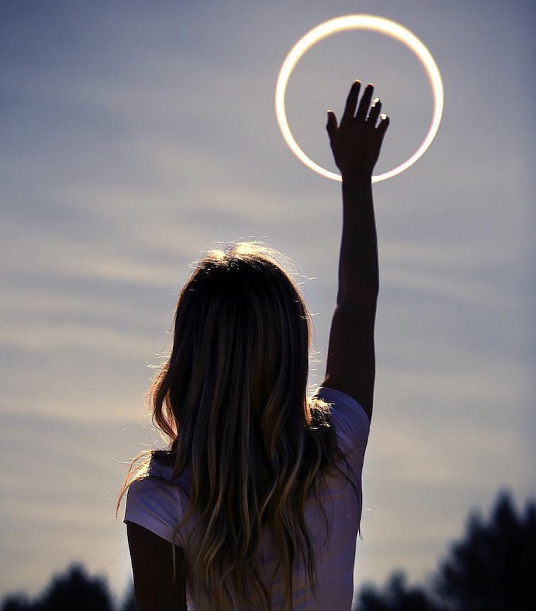 a woman holding a frisbee up in the air