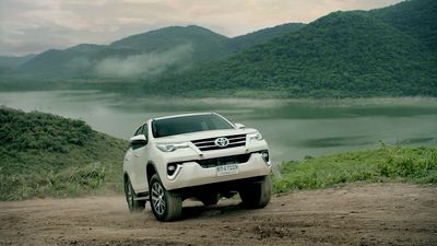 a white car driving down a dirt road