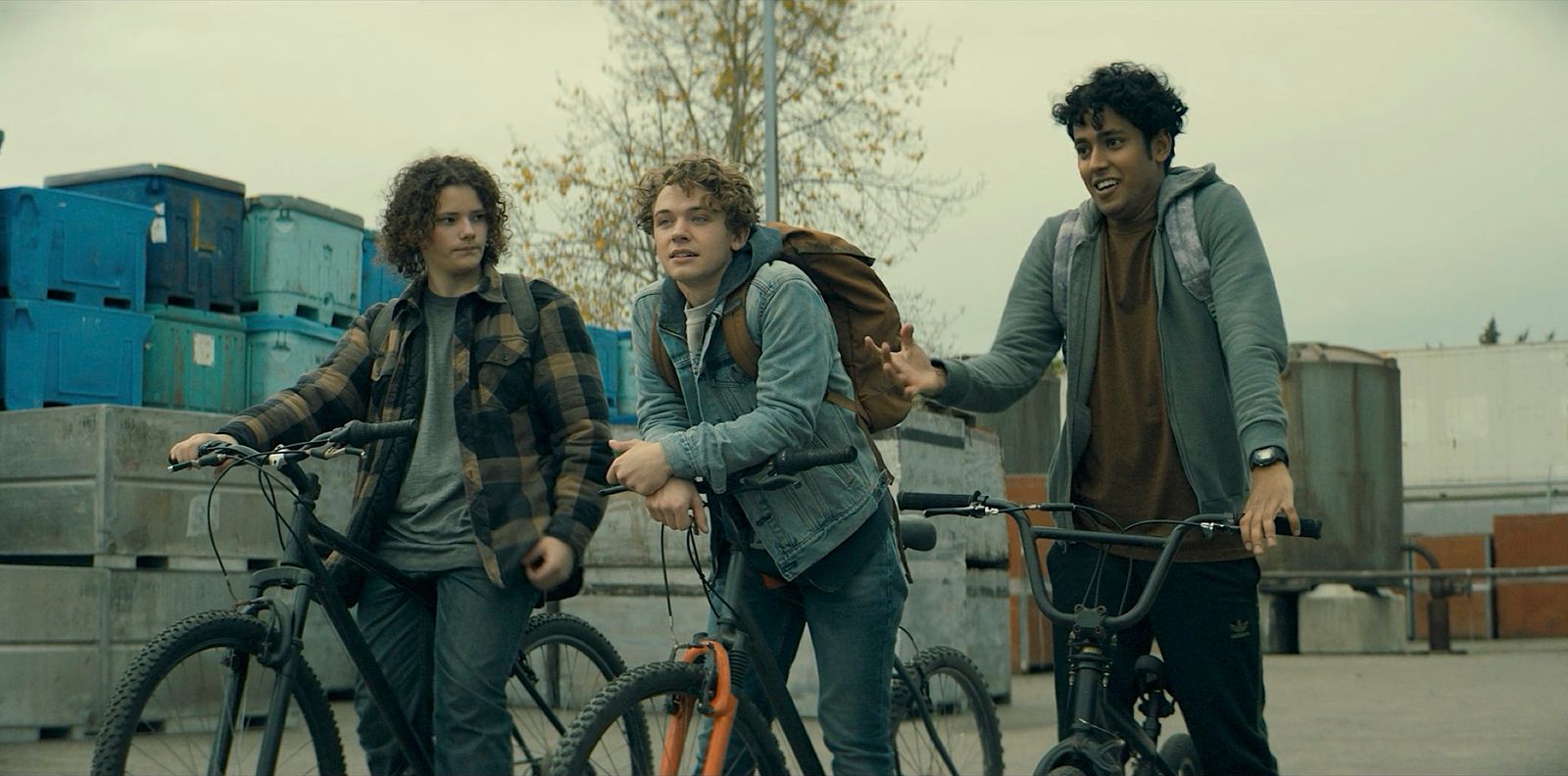 a group of young men riding bikes next to each other