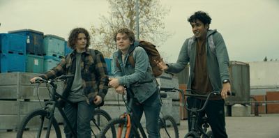 a group of young men riding bikes next to each other