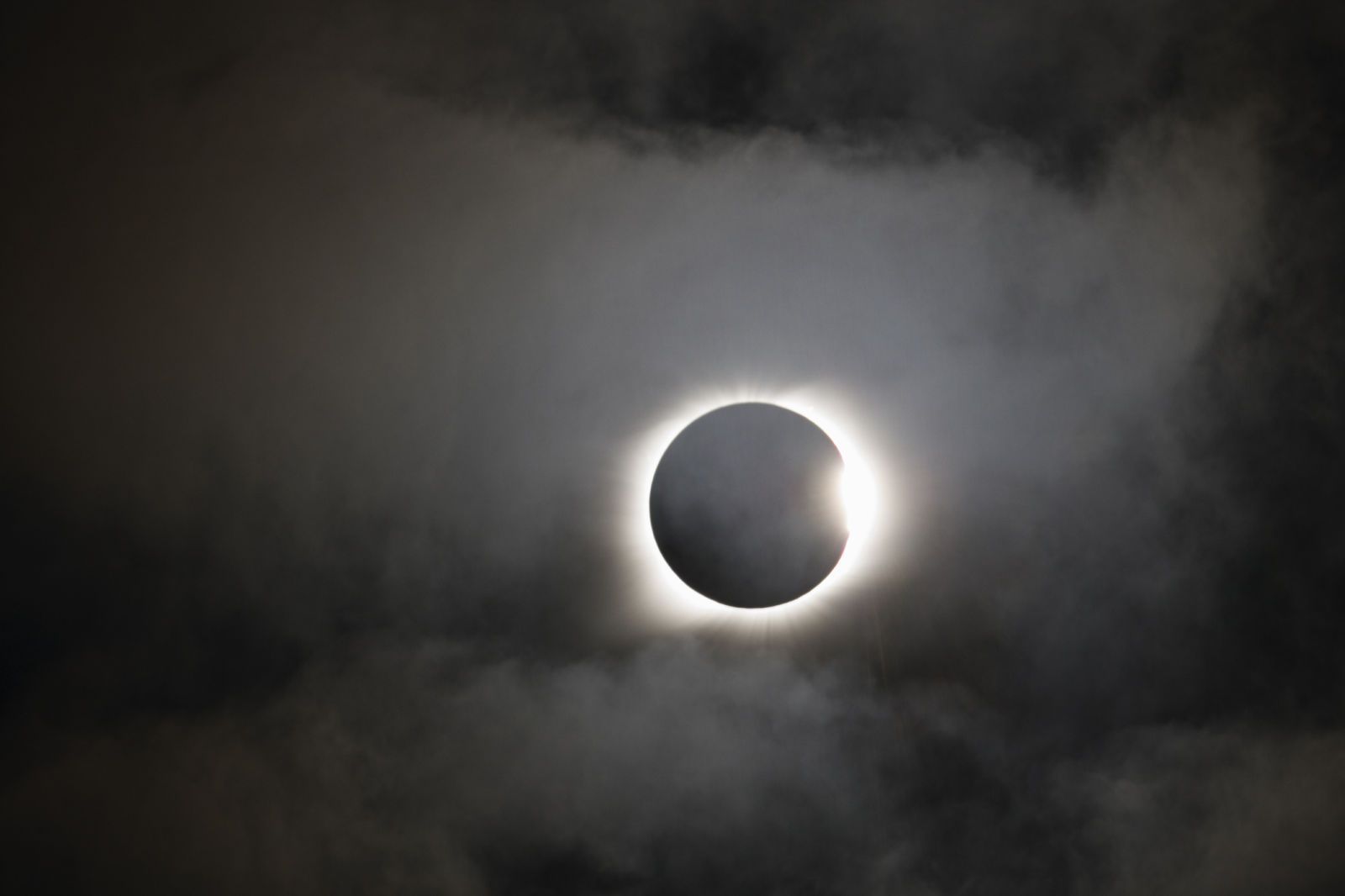 a solar eclipse is seen through the clouds