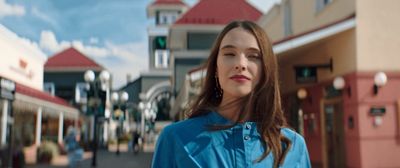 a woman standing in front of a building on a street