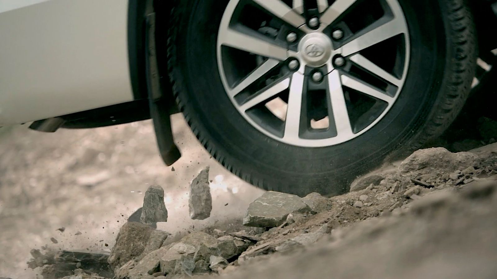 a close up of a car tire on a rocky road