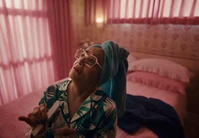 a woman in a green and white shirt and glasses