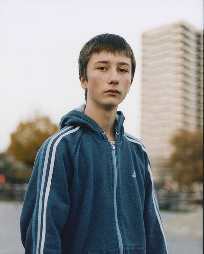 a young man standing in front of a tall building