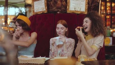 a group of women sitting at a table eating food