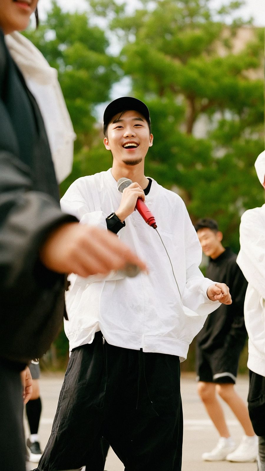 a young man holding a microphone while standing next to other people