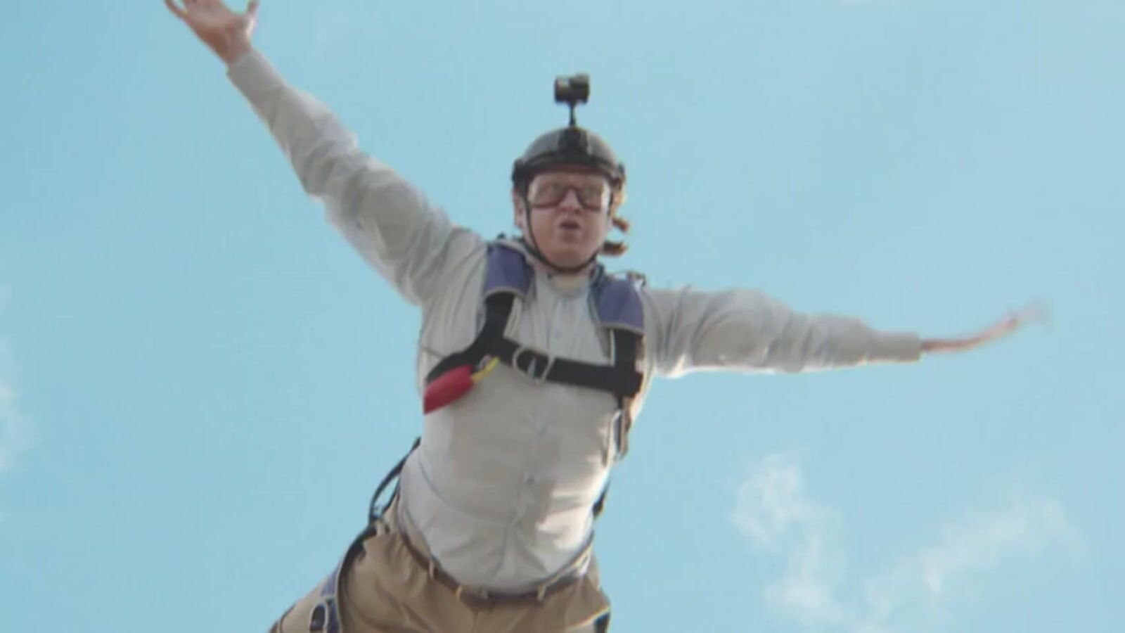 a man flying through the air while riding a parachute