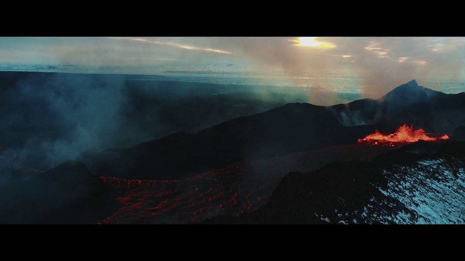 an aerial view of a volcano with lava pouring out of it