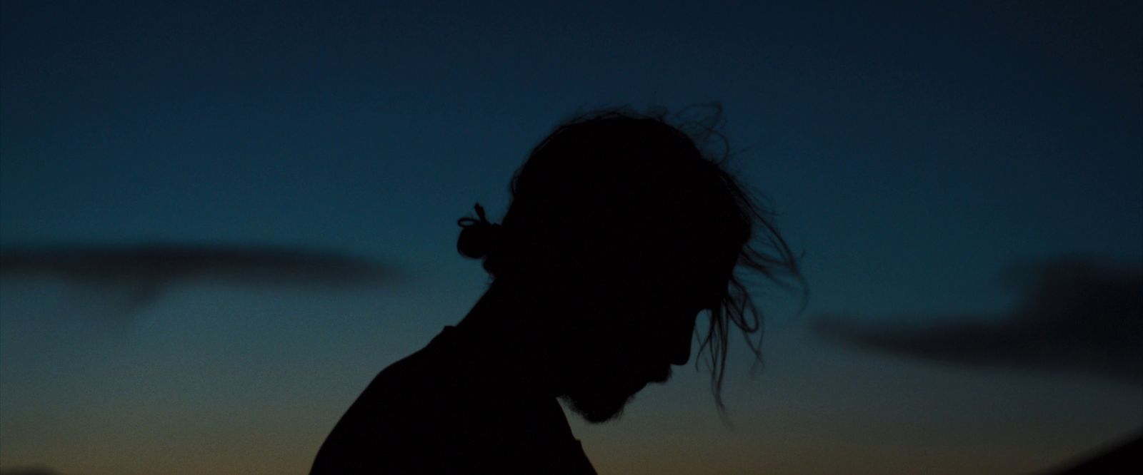 a silhouette of a man with a cigarette in his mouth