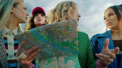 a group of women standing next to each other looking at a map