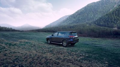 a car parked in a field with mountains in the background