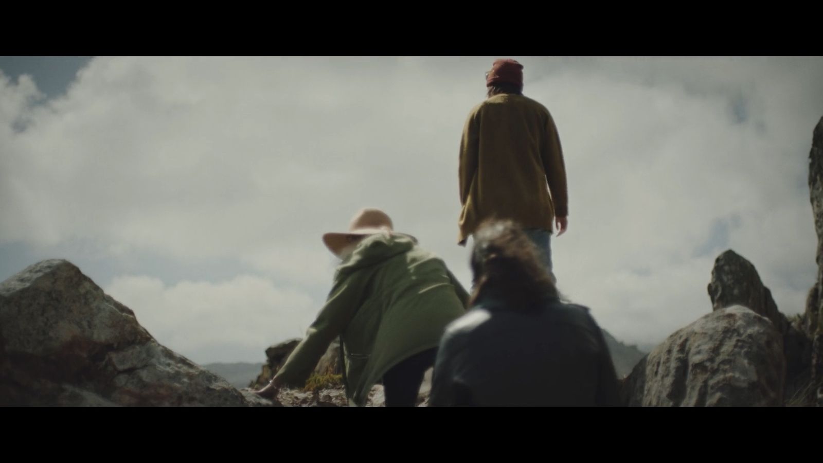 a man standing on top of a mountain next to another man