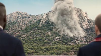 a man looking at a large plume of smoke coming out of a mountain