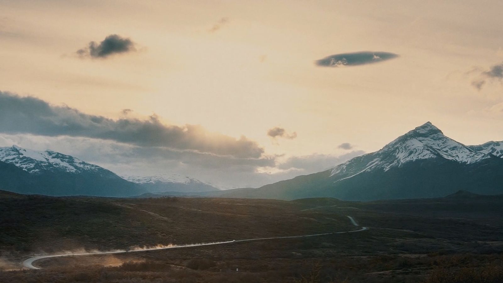 a view of a mountain range with a road in the foreground