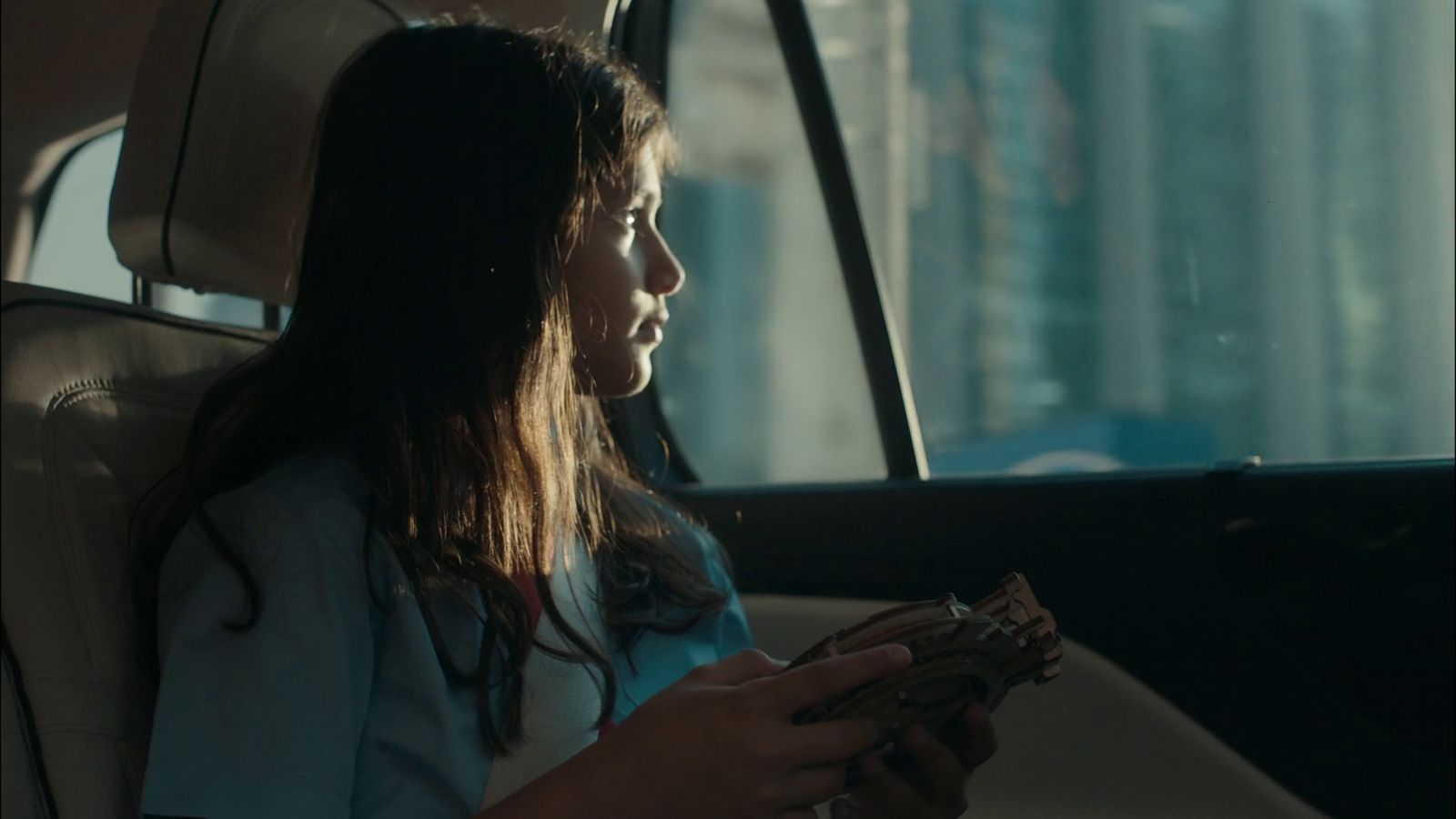 a woman sitting in a car looking at a cell phone