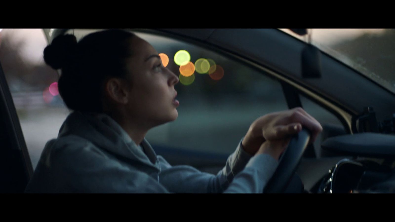 a woman driving a car at night time