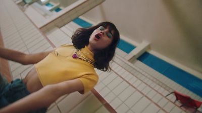 a woman in a yellow shirt is standing in a bathroom