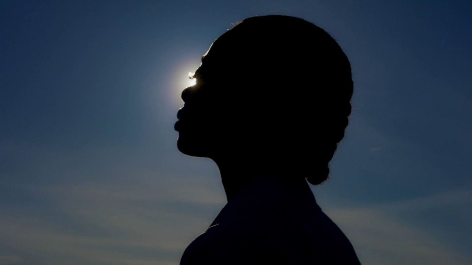 a silhouette of a person with the sun in the background