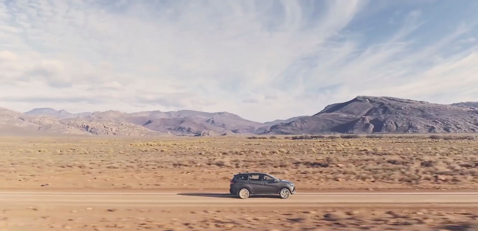 a car driving down a dirt road in the desert