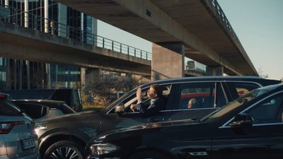 a group of cars driving down a street next to a bridge