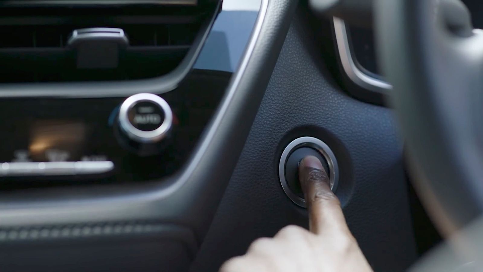 a hand on a steering wheel of a car